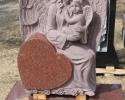 This is an India Red hand carved angel holding a baby sitting on a heart.  There is more room for engraving on the back.