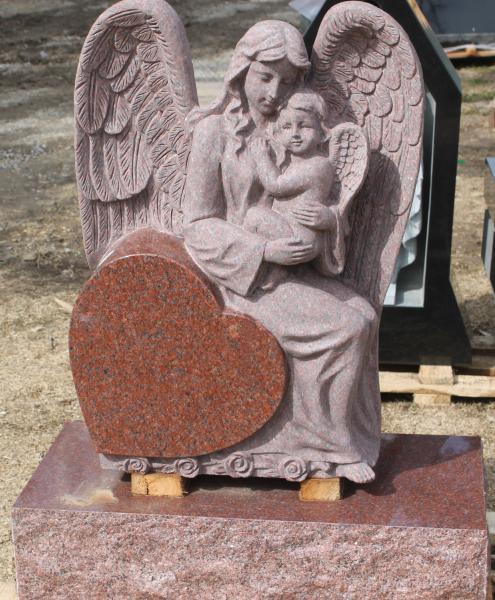 This is an India Red hand carved angel holding a baby sitting on a heart.  There is more room for engraving on the back.